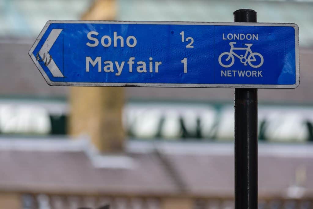 A signpost in central London directs cyclists towards Soho and Mayfair along the London Network